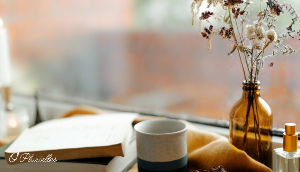 Tasse et livres près d'une fenêtre, pour l'article sur la carte cadeau d'une praticienne bien-être