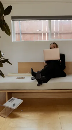 Femme qui travaille sur son ordinateur portable, assise sur une banquette